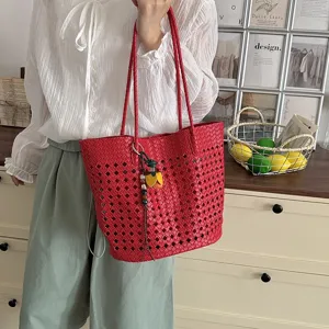 Detailansicht der roten gewebten Cutout-Umhängetasche mit stilvollem Fransen-Anhänger.