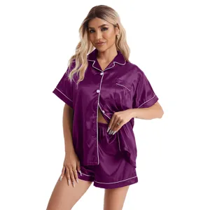 Detail view of women's short sleeve satin pajama set in dark purple with white piping.