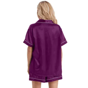Back view detail of women's short sleeve satin pajama set in dark purple with white piping.