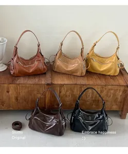 Detailed view of retro slouchy hobo shoulder bags in multiple colors featuring front zip pockets.