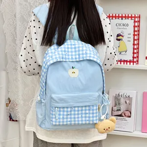 Sac à dos d'écolier à carreaux bleu clair mignon japonais avec broderie de pomme et pendentif.