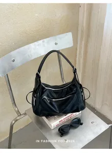 Detailed view of black leather hobo shoulder bag, stylish retro commuting bag with zippers.