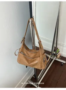 Detail view of vintage brown PU leather shoulder hobo bag with zipper pockets and metal accents.