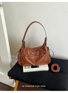 Brown vintage shoulder bag detail showcasing premium leather material and multiple zippers.