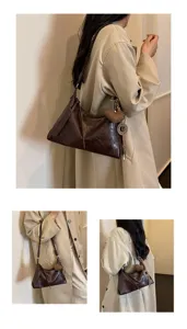 Sac à bandoulière marron vintage avec sangle tressée et pendentif chic, vue de détail.