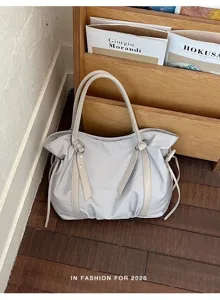 Casual grey tote bag with shoulder straps, stylish daily commuter handbag detail view.