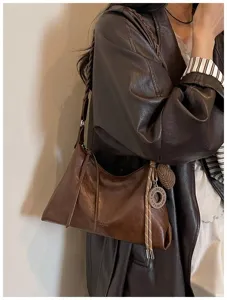 Sac bandoulière rétro en cuir marron pour femmes, design hobo élégant avec pendentif et bride.