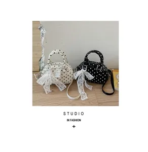 Stylish polka dot handbag with elegant lace bow detail, perfect for casual and daily wear.