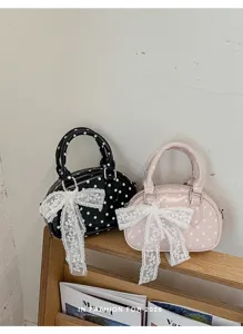 Polka dot handbag detail view showing the cute lace bow and classic shape for women summer fashion
