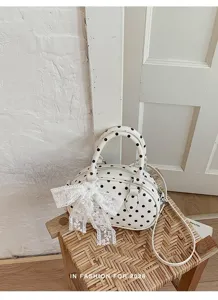 White polka dot handbag detail, chic lace bow decor, stylish summer shoulder bag view.
