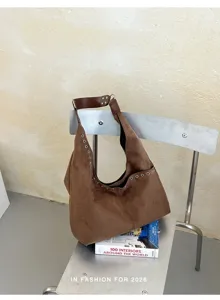 Braune weiche Wildleder-Hobo-Umhängetasche mit stilvollen Metalldurchführungen und Riemen.