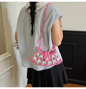 Detailed shot of a pink and grey hand-knotted crochet crossbody bag with a star button.