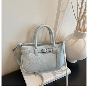 Gedetailleerd overzicht van lichtblauwe lederen handtas, elegante lifestyle scène met vaas.
