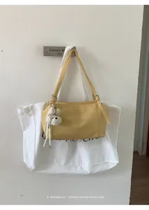 Vista detallada del elegante bolso de hombro amarillo con correas dobles finas y colgante.