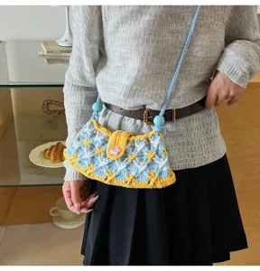 Handcrafted knitted crossbody bag with blue and yellow plaid pattern, cute floral accent.