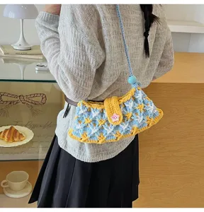 Knit crossbody bag detail view, colorful woven pattern with cute star button and strap.