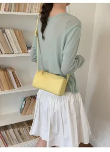 Vista detallada de un bolso cilindrico amarillo, disenio minimalista para uso diario.