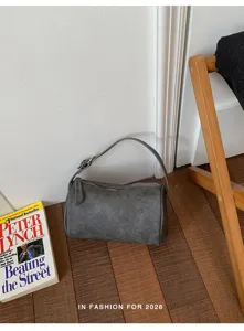 Vista detallada del bolso de hombro cilíndrico gris minimalista, bolso casual diario.