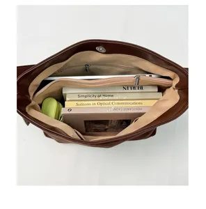 Brown leather tote bag interior view showing large capacity, multiple compartments and lining.