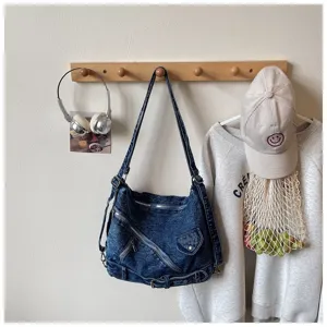 Casual denim shoulder bag with multiple zipper pockets and vintage washed finish design.