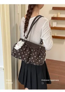 Vue détaillée du sac porté épaule marron à fleurs, avec nœud et joli pendentif lapin.