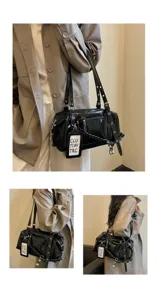 Detailed view of the black patent leather shoulder bag showing zipper pockets and strap.
