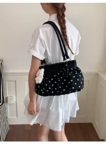 Vue détaillée du sac porté épaule noir à motif floral blanc avec joli pendentif lapin.