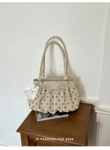Vue détaillée du sac seau beige élégant doté d'un imprimé floral délicat et d'un joli nœud.