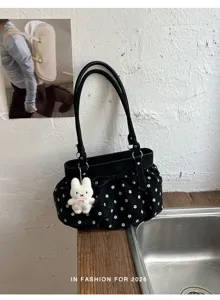 Détail de sac porté épaule floral noir avec pendentif lapin mignon et nœud pour l'été.