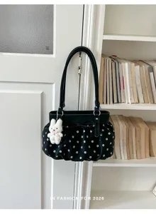 Vue détaillée d'un sac porté épaule noir élégant à motif floral blanc et charmant pendentif lapin.