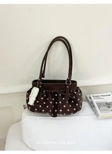 Sac à bandoulière marron avec motif de fleurs blanches, joli pendentif lapin et nœud élégant.