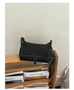Black woven leather shoulder bag detail, minimalist retro style crossbody mini handbag.