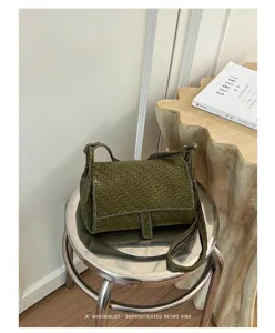 Detail shot of an olive green woven leather crossbody bag with a chic flap and retro vibe.