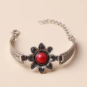 Detail close-up of retro silver flower bracelet featuring a striking red center bead.