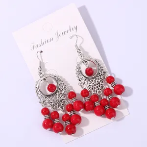 Vintage bohemian red beaded long tassel earrings featuring intricate antique silver metal details.