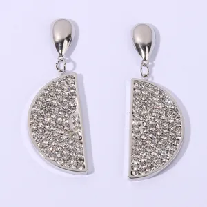 Close-up detail of silver rhinestone paved half-circle lemon slice drop earrings, shiny design.