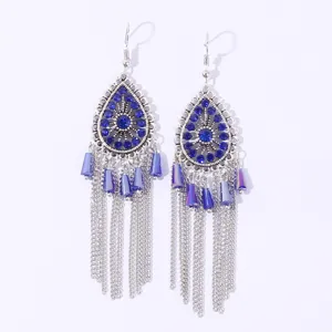 Close-up detail of bohemian blue rhinestone drop earrings with silver fringe chains.