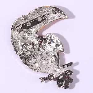 Toucan bird brooch pin back detail shot, metal alloy fashion accessory fastener craftsmanship display.