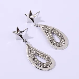 Close-up view of sparkling silver star and crystal rhinestone teardrop earrings.