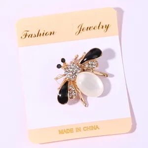 Close-up detail of exquisite rhinestone bee brooch with white stone and black enamel wings.