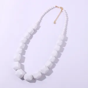 Collana di perle in acrilico geometrico bianco con chiusura dorata e catena di estensione.
