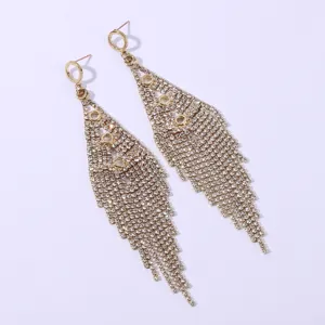 Detail shot of long rhinestone fringe earrings, sparkling gold fashion jewelry for women.