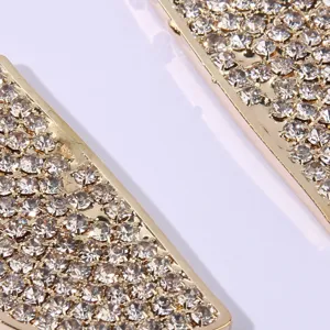 Close-up detail of luxury rhinestone embedded gold tone metal accessory sparkling beautifully.