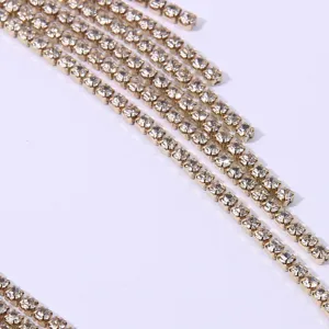 Close-up view of gold-toned rhinestone fringe chains, sparkling crystal tassel detail accessory.
