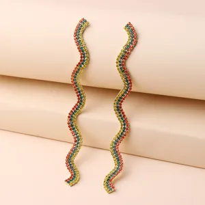 Detailed view of long wavy multi-color rhinestone tassel earrings, sparkling crystal detail.