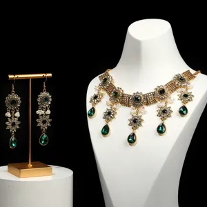 Detail shot of baroque crystal necklace and earrings set with green teardrop gemstones.