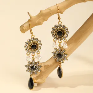 Close-up detail of vintage baroque crystal rhinestone dangle earrings with faux pearls.