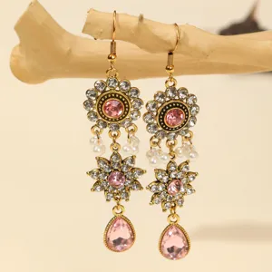 Close-up detail of vintage baroque style rhinestone floral dangling earrings with pink crystals.