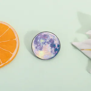 Detailed close-up of a stylish circular moon pattern metal brooch, perfect accessory.