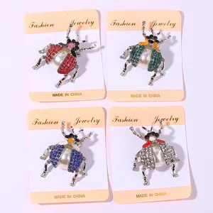 Elegant rhinestone beetle brooch set with pearl body and detailed metallic legs.